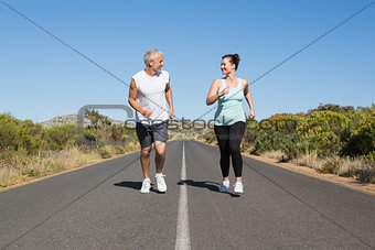 Fit couple running on the open road together