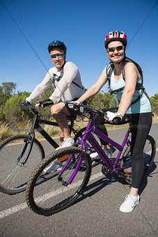 Active happy couple going for a bike ride in the countryside