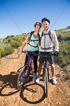 Active couple embracing on a bike ride in the country