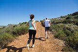 Fit couple jogging up mountain trail