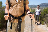 Hiking couple walking on mountain trail with poles