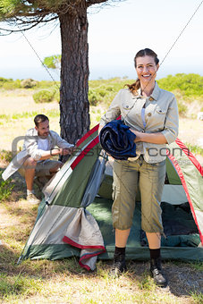 Outdoorsy couple setting up camp in the countryside