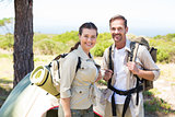 Outdoorsy couple smiling at camera outside their tent