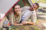 Outdoorsy couple smiling at camera inside their tent