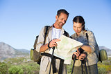 Hiking couple consulting the map in the countryside