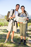 Hiking couple consulting the map in the countryside