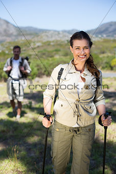 Hiking couple smiling at camera in the countryside