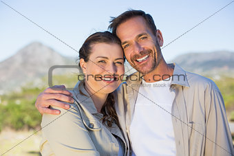 Hiking couple smiling at camera in the countryside