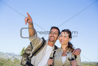 Hiking couple pointing and looking in the countryside