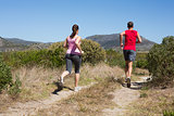 Active couple jogging on country terrain