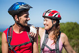 Active couple cycling in the countryside smiling at each other