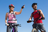 Fit cyclist couple standing at the summit