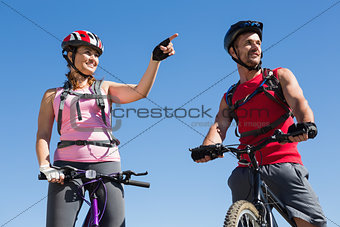 Fit cyclist couple standing at the summit