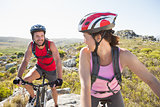 Fit cyclist couple riding together on mountain trail