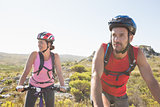 Fit cyclist couple riding together on mountain trail