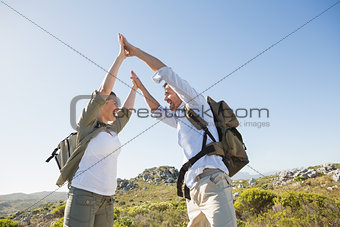 Hiking couple high fiving on mountain terrain