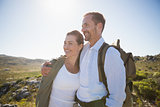 Hiking couple embracing and smiling on country terrain