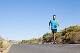 Athletic man jogging on the open road