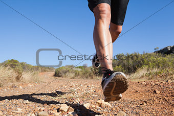 Athletic man jogging on country trail