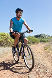 Fit cyclist riding on country trail