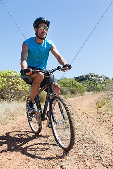 Fit cyclist riding on country trail