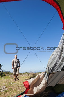 Happy camper walking towards his tent