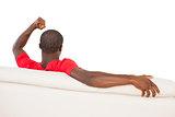 Man in red jersey sitting on couch cheering