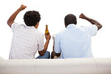 Cheering sports fans sitting on the couch with beers