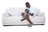 Man sitting on couch learning to play guitar with his tablet pc