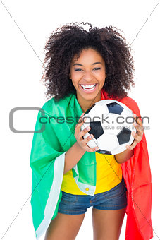 Pretty football fan with portugal flag holding ball