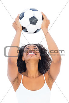 Pretty girl holding football and smiling