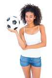 Pretty girl holding football and smiling at camera