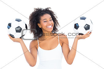 Pretty girl holding footballs and smiling at camera