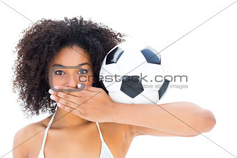 Smiling fit girl in white bikini holding football