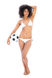 Beautiful fit girl in white bikini holding football
