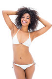 Fit girl in white bikini smiling at camera