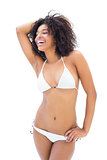 Fit girl in white bikini smiling and posing
