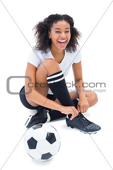 Pretty football player in white tying her shoelace