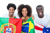 Happy football fans holding flags smiling at camera