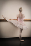 Beautiful ballerina warming up with the barre