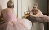 Beautiful ballerina warming up with the barre