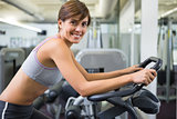 Fit brunette working out on the exercise bike