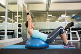 Fit brunette using bosu ball to work out