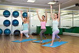 Yoga class in warrior pose in fitness studio
