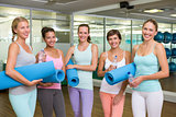 Smiling women in fitness studio before yoga class