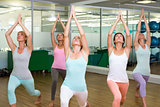 Yoga class in warrior pose in fitness studio