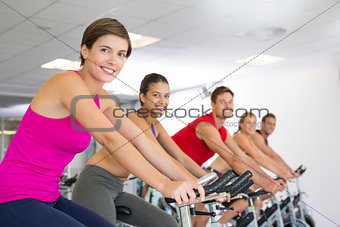 Spin class working out and smiling at camera