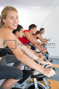 Blonde smiling at camera during spin class