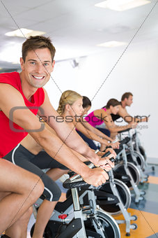 Man smiling at camera during spin class