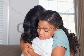 Mother and daughter hugging on the couch